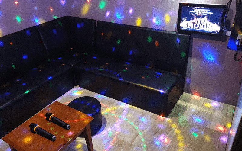 Grandlink karaoke room with black sofa and colorful lights
