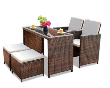 Wicker table, 2 wicker chairs, and 2 wicker stools, with cushions on top of the chairs and stools