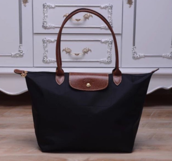 a classy black tote bag with a brown leather handle and clasp