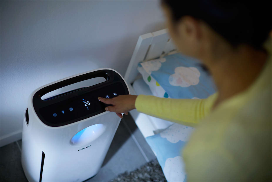 Woman turning on Philips air purifier at night
