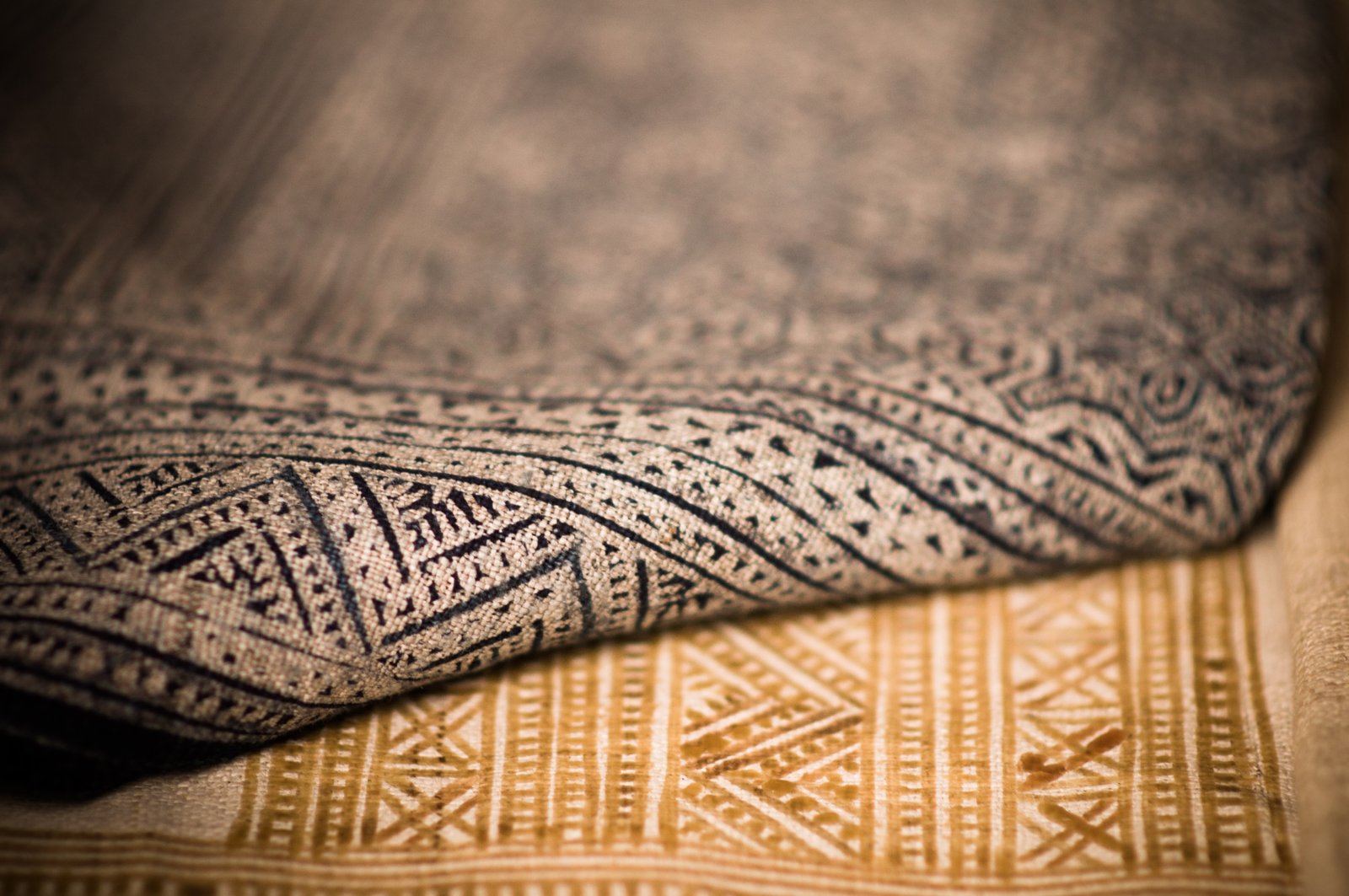 Brown carpet folded at a corner over a beige carpet